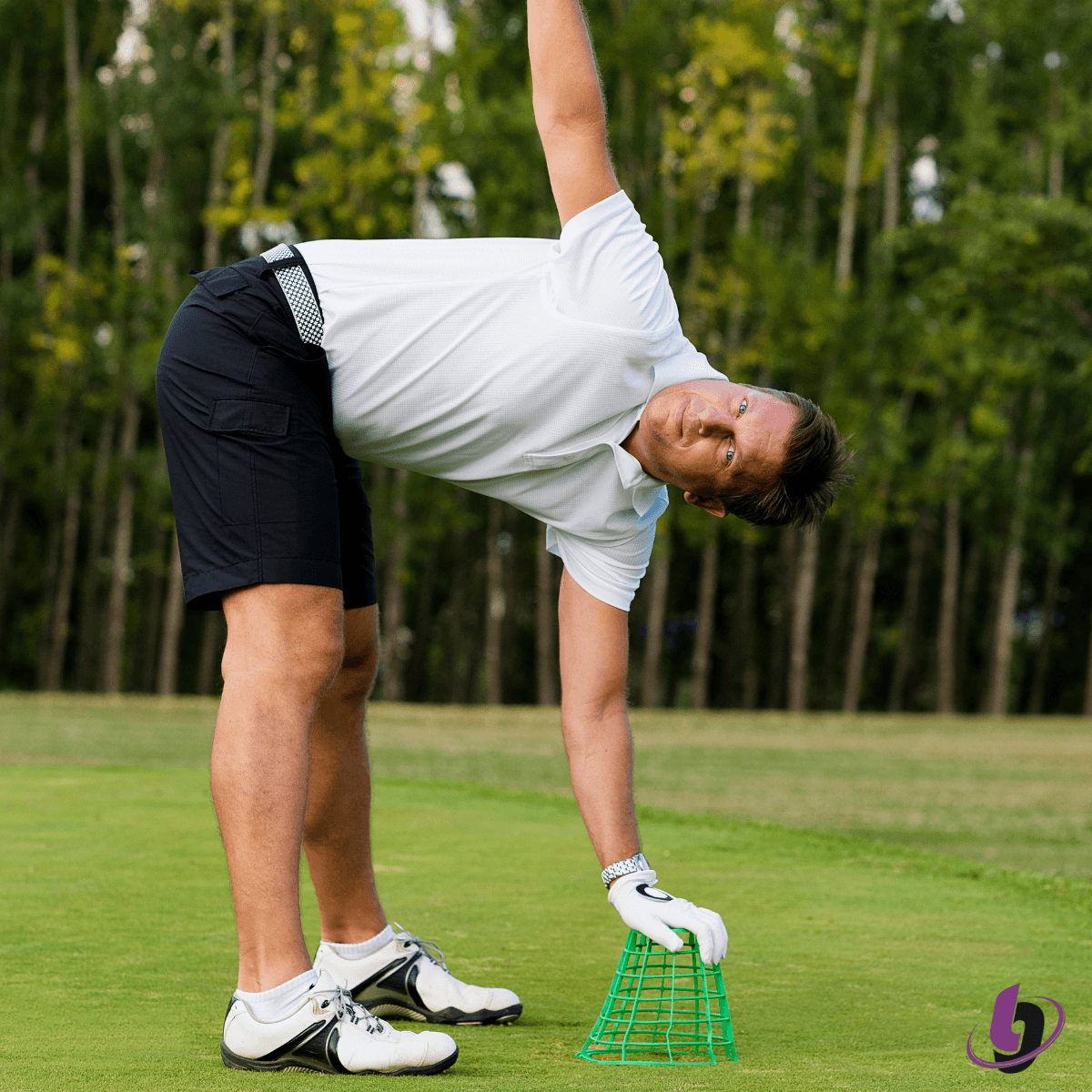 Golfer performing side bend stretch on golf course before swing to improve flexibility and mobility Golfer performing side bend stretch on golf course before swing to improve flexibility and mobility