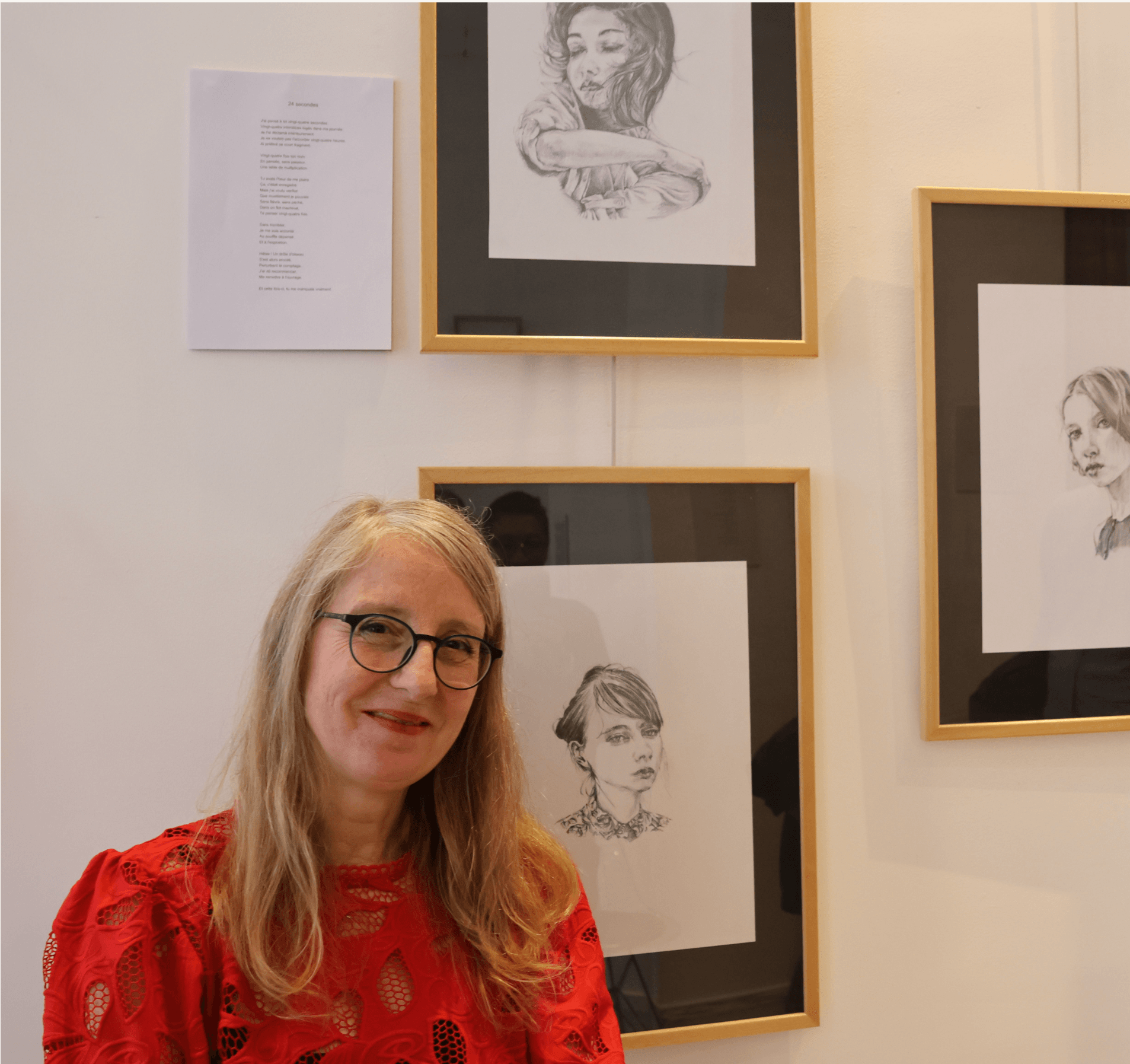 Portrait de l'illustratrice Fabienne Didier en chemisier rouge devant l'exposition de dessins. Portrait de l'illustratrice Fabienne Didier en chemisier rouge devant l'exposition de dessins.