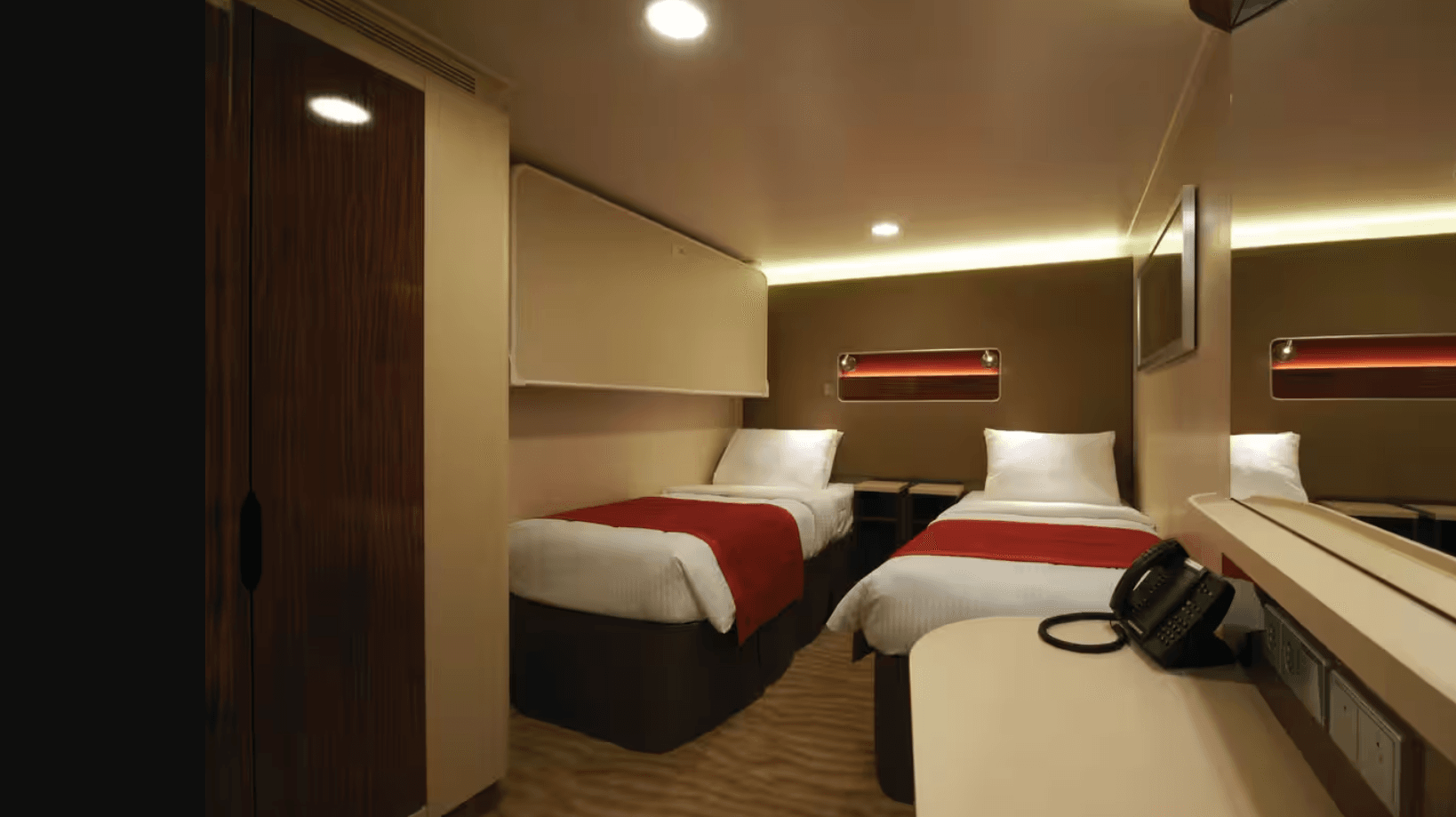 Cozy NCL inside stateroom with a comfortable bed, warm lighting, and modern cruise cabin décor.