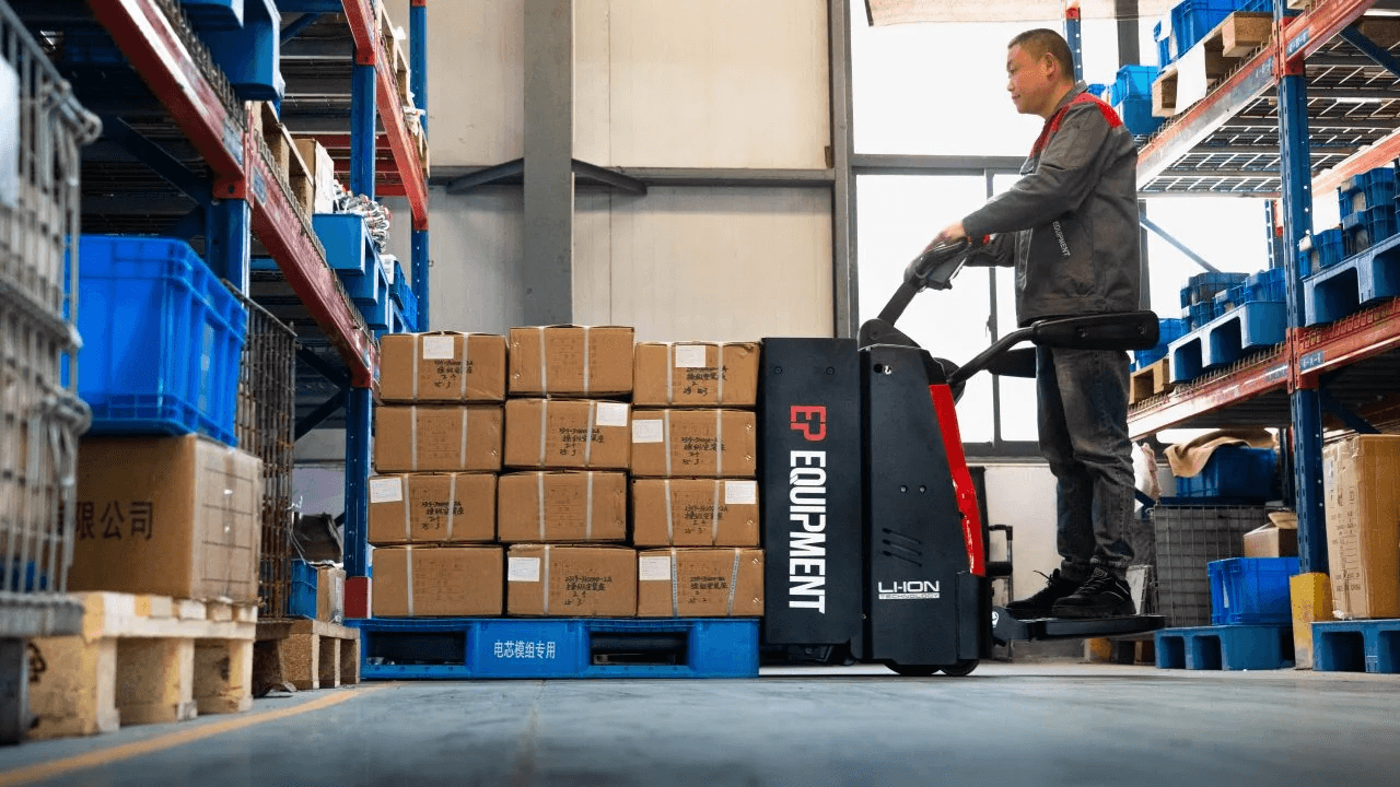 Ride-on pallet truck in a warehouse