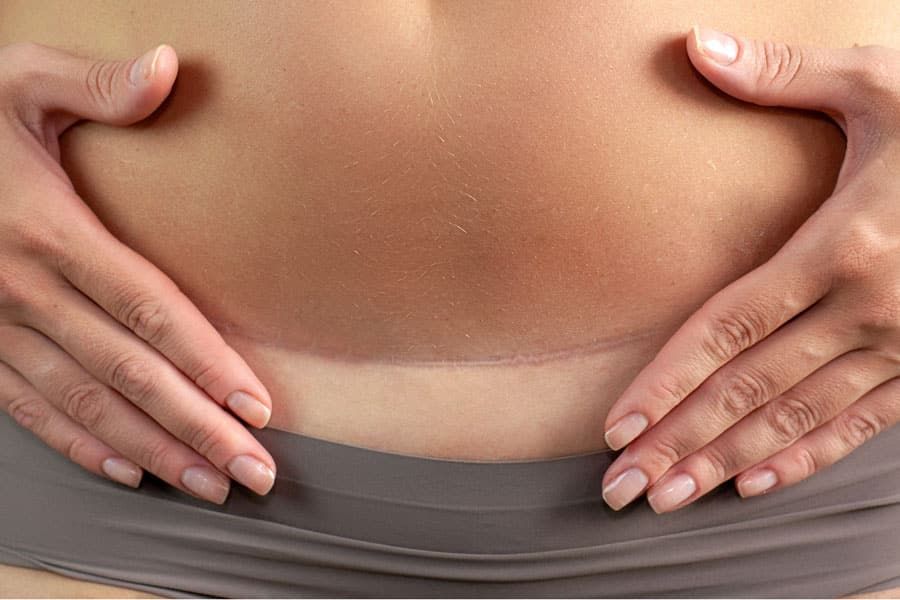 Pregnant woman cradling her belly in soft natural light, expressing maternal tenderness and connection to her unborn child