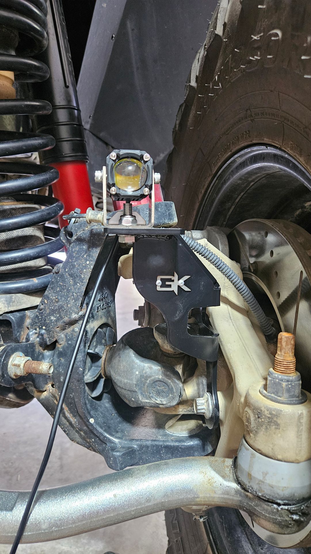 Close-up of knuckle light mounted near Jeep front steering and suspension by Red White and Glow in Manchester Tennessee