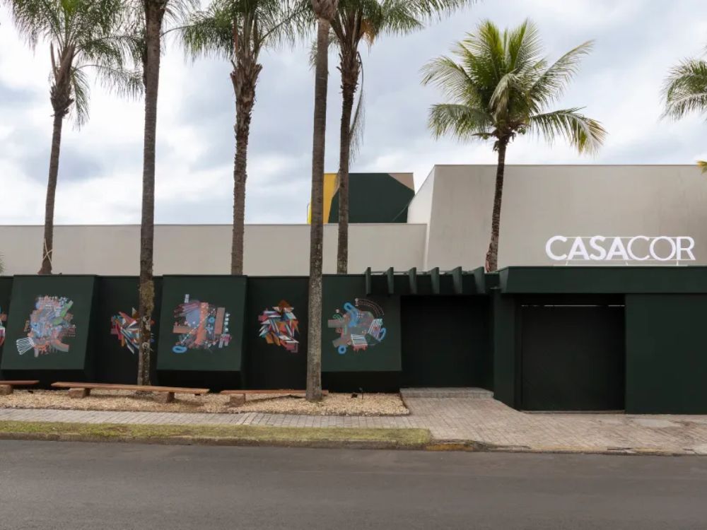 Fachada principal com cores escuras e grafite nos elementos de sombreamento