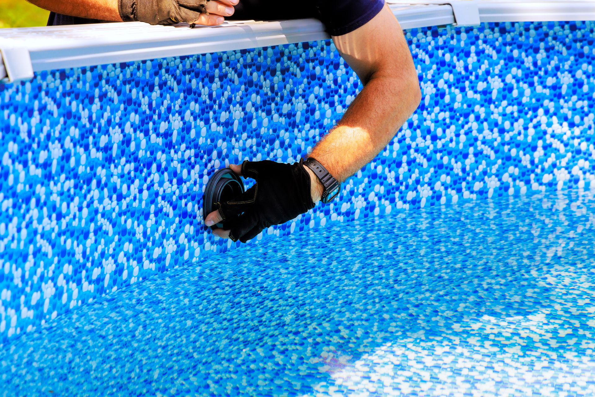 worker installing a water filtration device in a pool