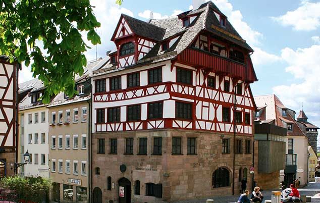 Historic half-timbered home of Albrecht Dürer in Nuremberg, Germany, featuring red-and-white timber framing, steep gabled roofs, and traditional medieval architecture.