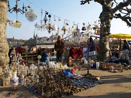 Antique lamps, vintage collectibles, and unique treasures on display at the Frankfurter Flohmarkt, Frankfurt's popular open-air flea market, where visitors browse local antiques, artwork, and one-of-a-kind finds.