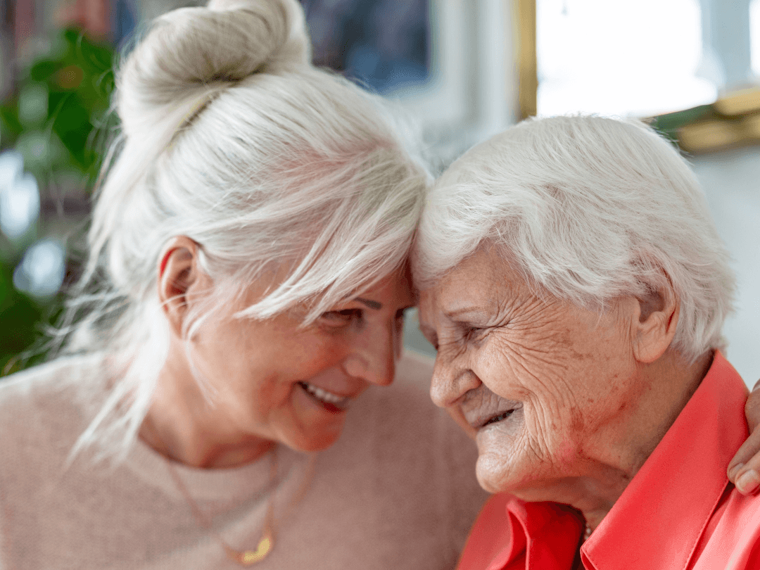 Elderly mom and daughter hugging and smiling