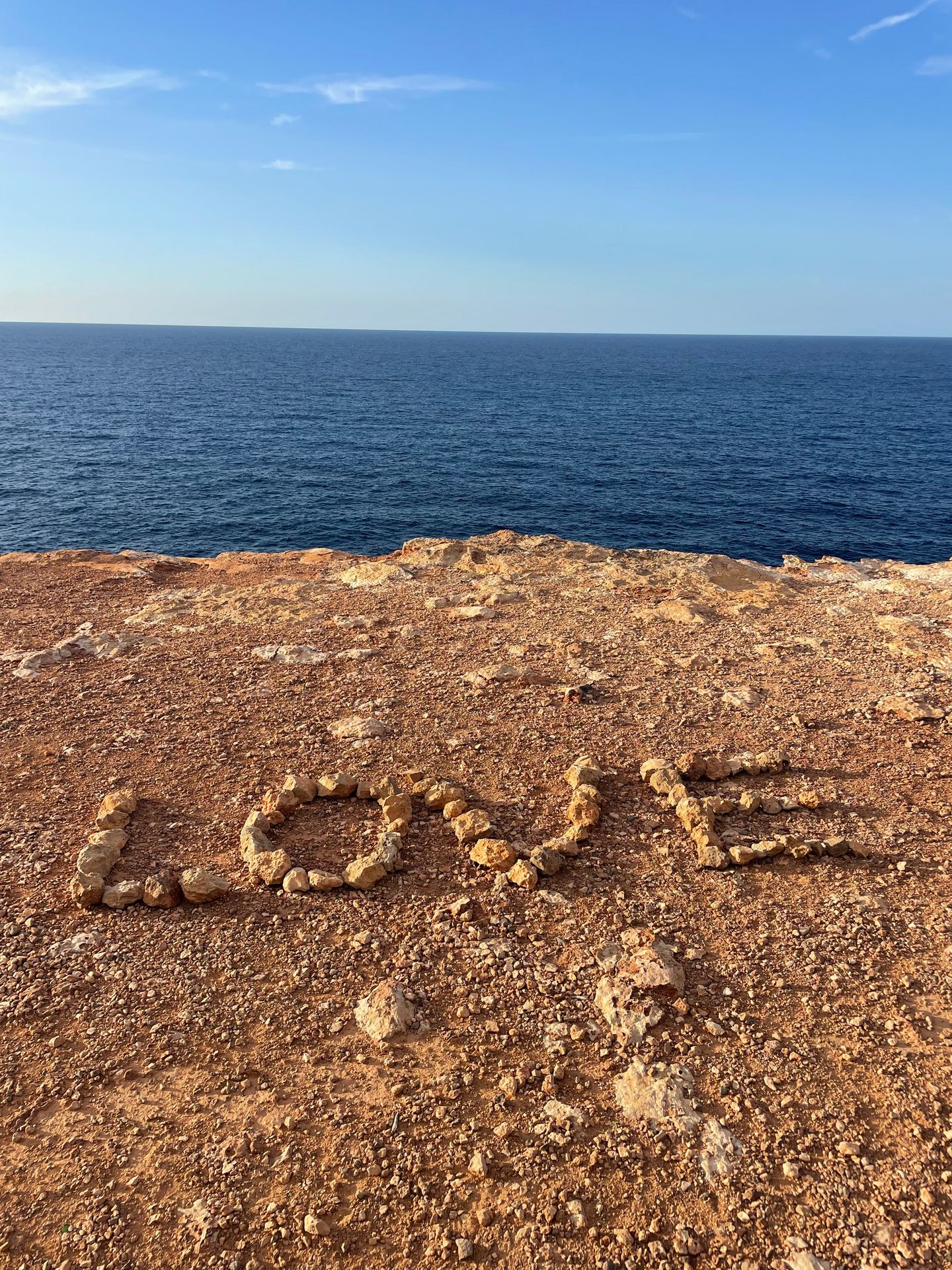 Quiet Ibiza beach in October with turquoise Mediterranean sea and autumn sunlight