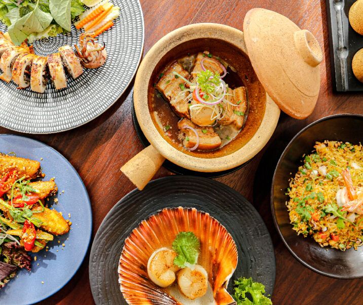 A vibrant display of gourmet dishes, including seafood, stir-fried rice, and grilled meat, served on elegant plates at an all-inclusive resort restaurant. A vibrant display of gourmet dishes, including seafood, stir-fried rice, and grilled meat, served on elegant plates at an all-inclusive resort restaurant.