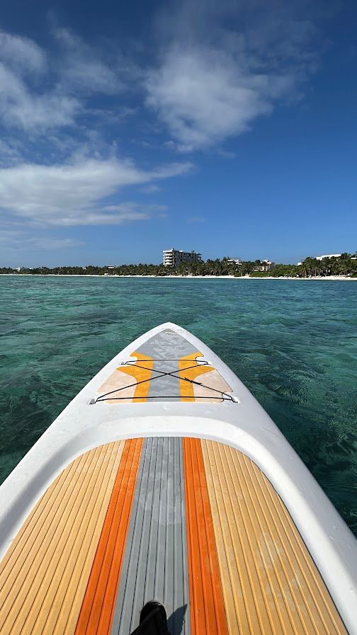 Guest paddleboarding on calm Soliman Bay in front of Jashita Hotel