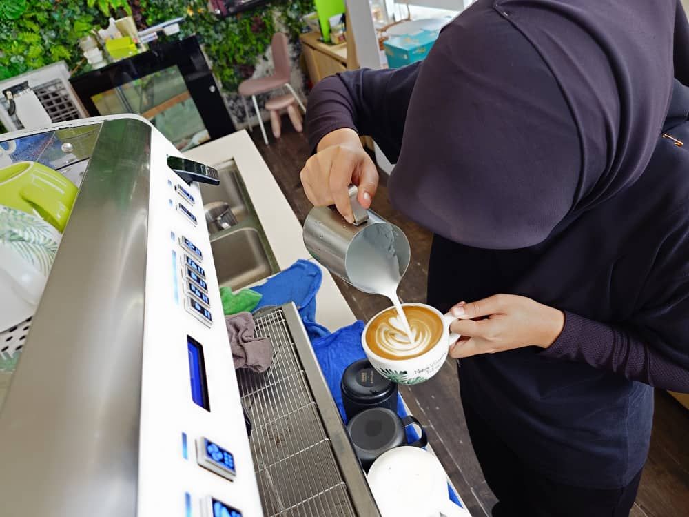 HRDC Trainee pouring latte art tulip during CAN Academy barista training in Klang