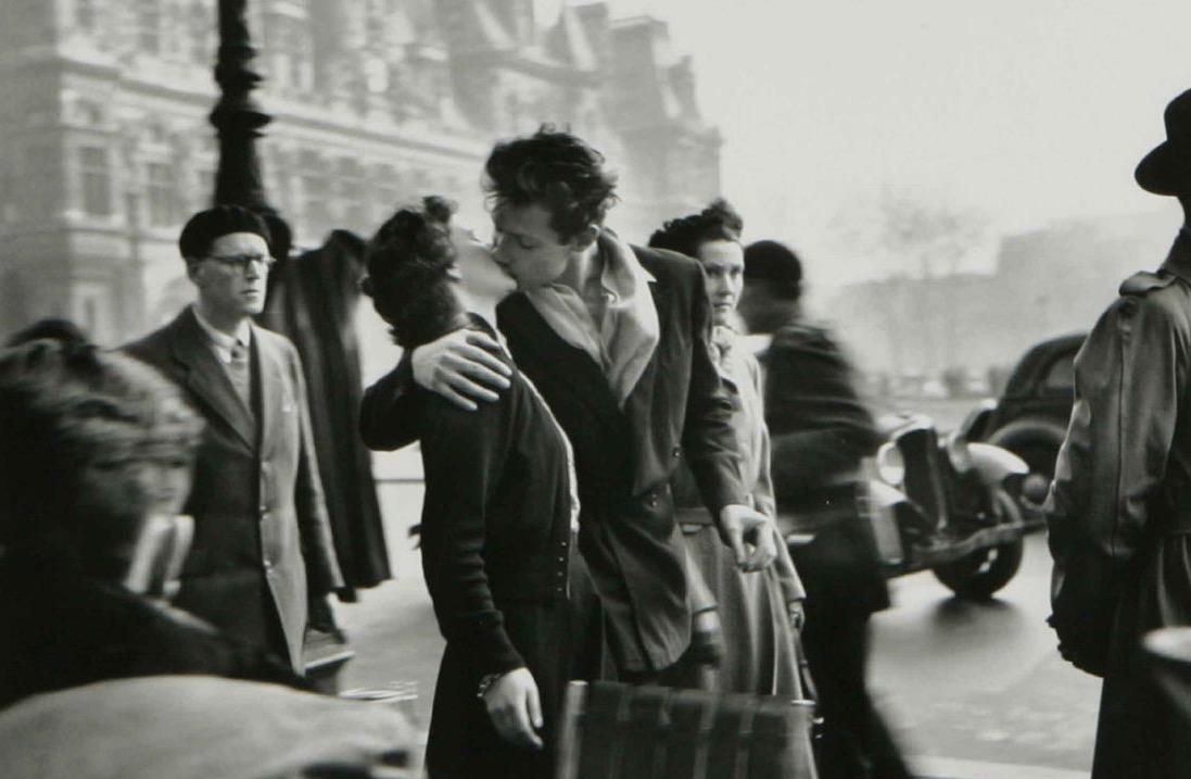 Un homme et une femme s'enlacent et s'embrassent devant une foule.
