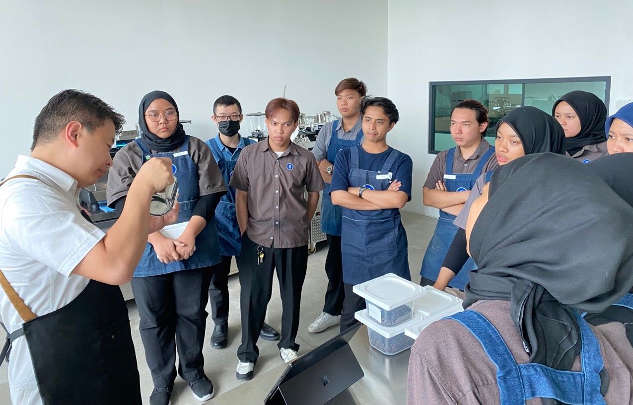 SKM barista class group instruction with trainer demonstrating technique at CAN Academy