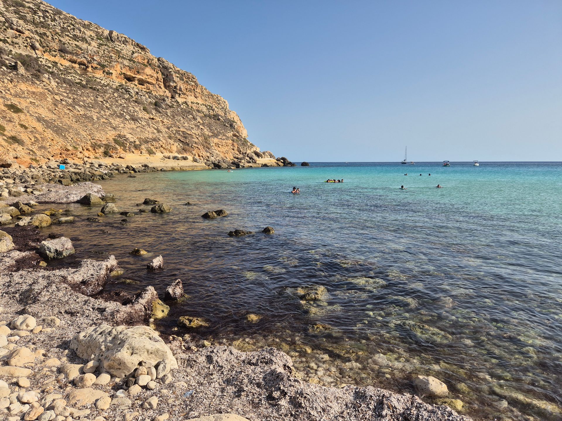 a group of people on a beach next to a body of water a group of people on a beach next to a body of water