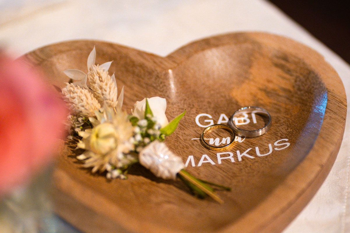 Eheringe auf einem hölzernen Ringkissen bei einer Hochzeit in Oberösterreich Eheringe auf einem hölzernen Ringkissen bei einer Hochzeit in Oberösterreich