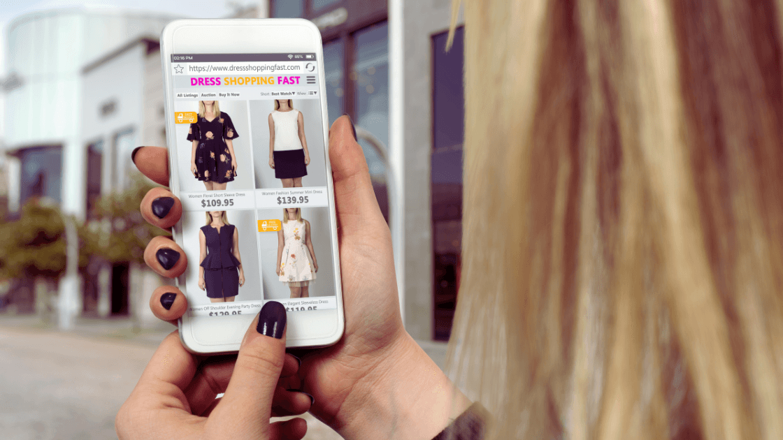 BlackFriday_Mulher com celular na mão vendo roupas