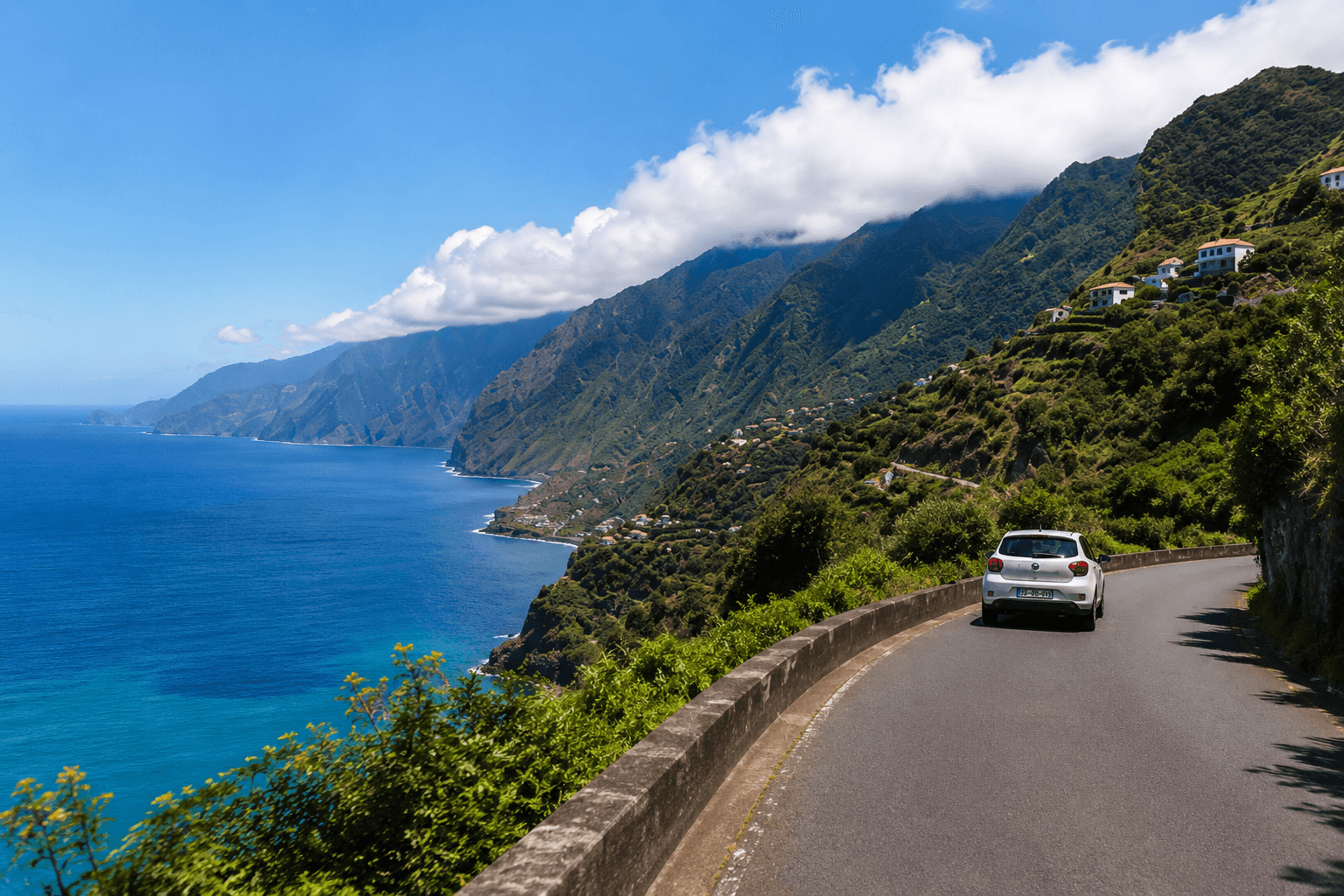 Rental car driving on a scenic mountain road in Madeira between the mountains and the Atlantic Ocean Rental car driving on a scenic mountain road in Madeira between the mountains and the Atlantic Ocean