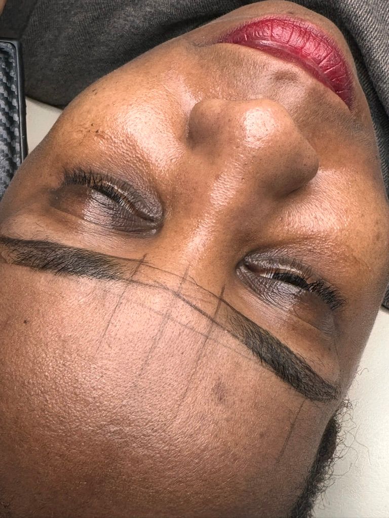 Beautician designing eyebrows before microblading treatment