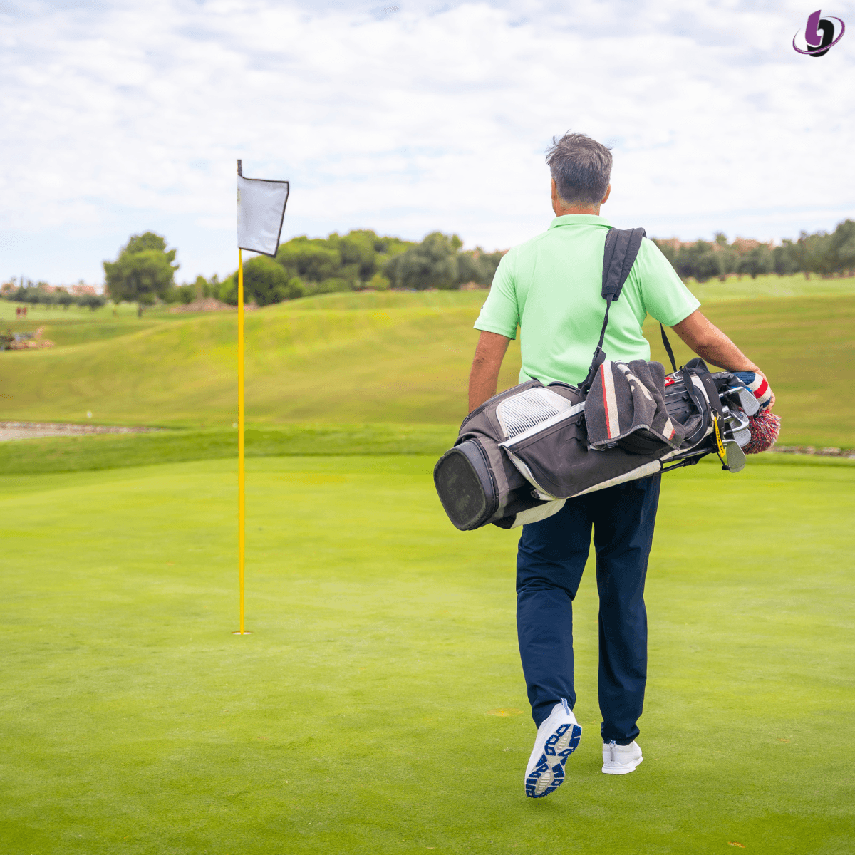 Golfer carrying clubs walking off the green Golfer carrying clubs walking off the green