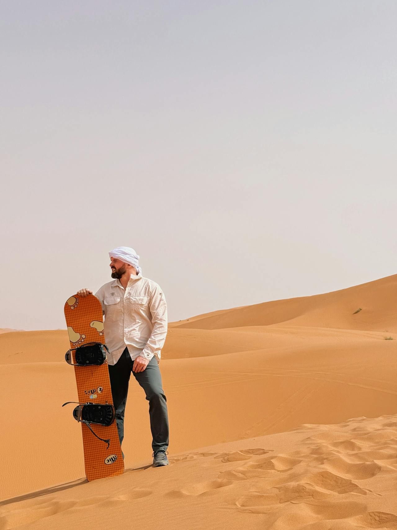 Man sandboarding in desert Man sandboarding in desert