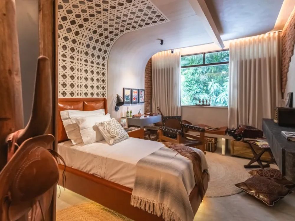 Quarto com tons crus e detalhe da cabeceira da cama ao teto 