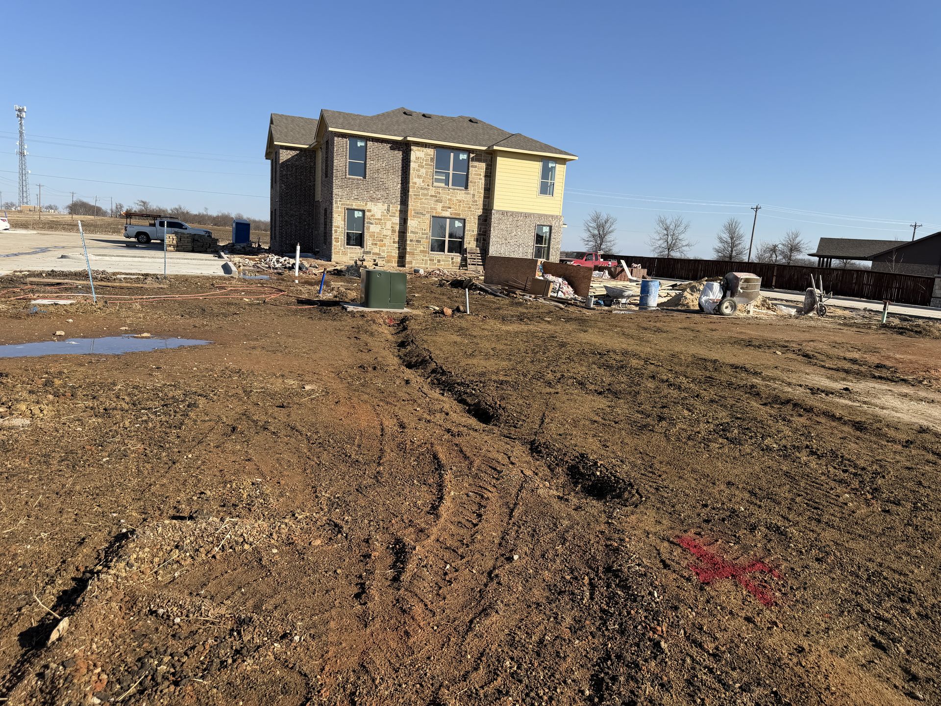 Private utility locating at a residential construction site in Ponder, TX with APWA markings visible before excavation