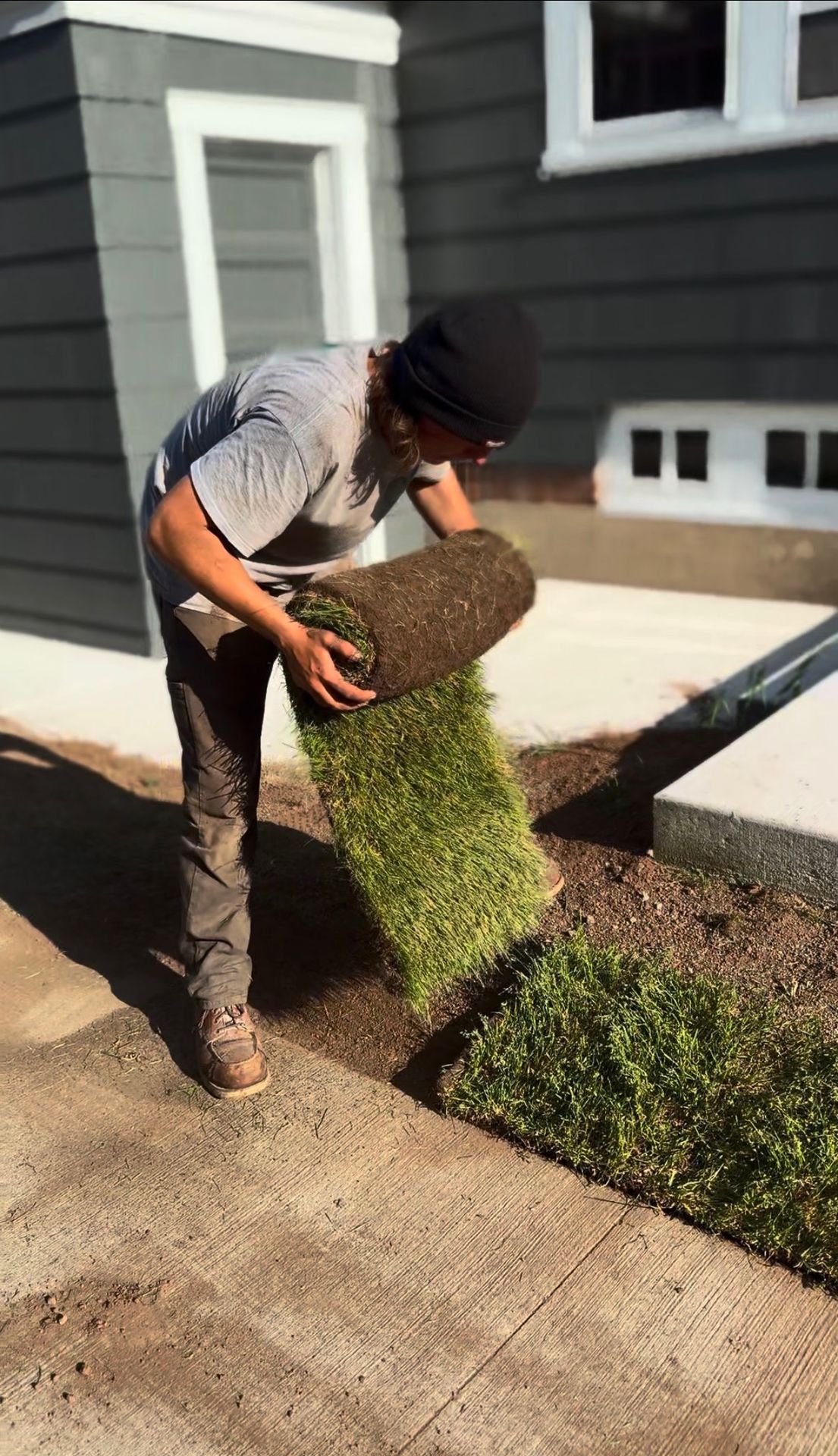 Yard & Beyond Solutions crew laying sod beside a home