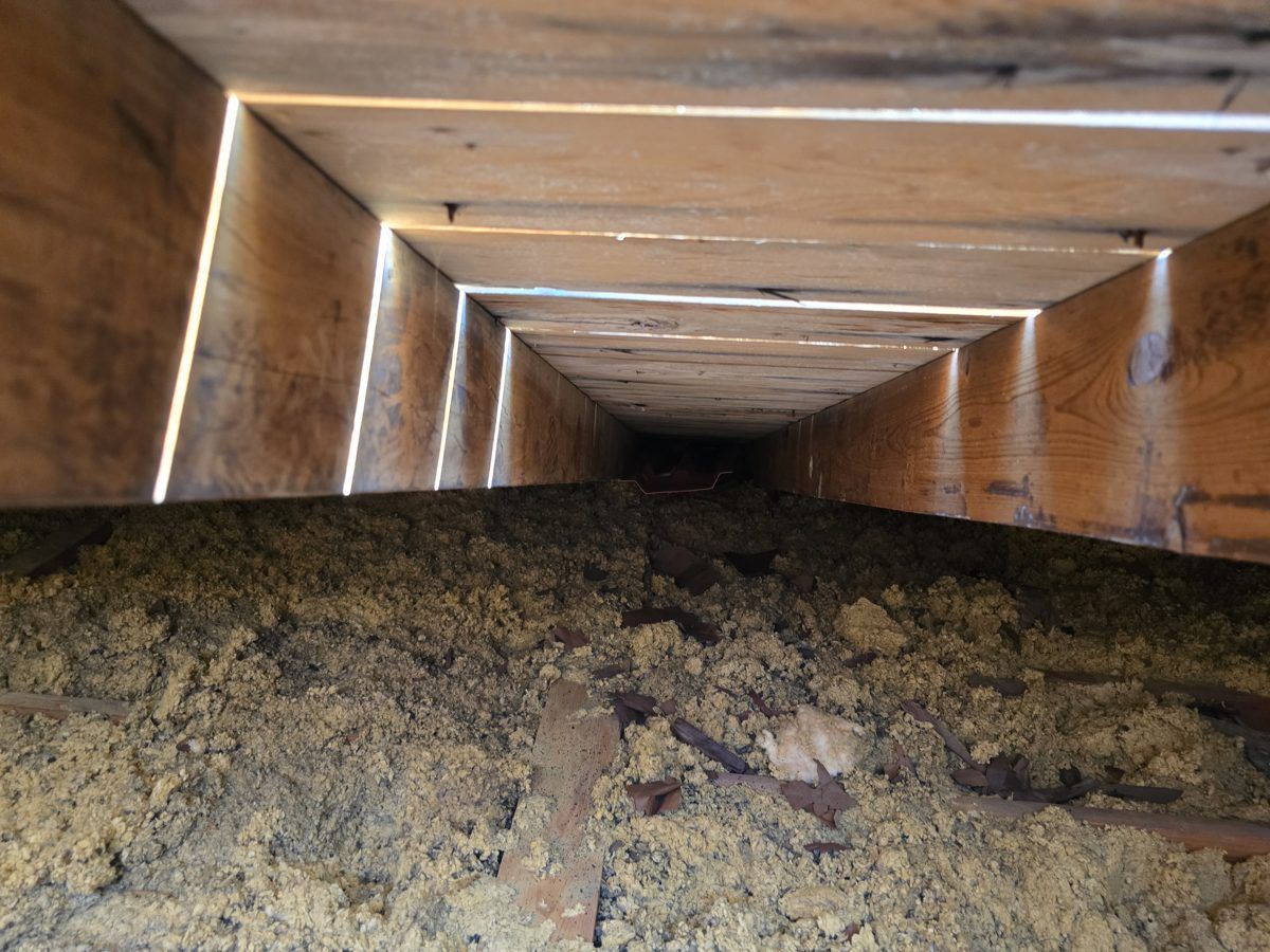 Old settled insulation between attic rafters before MichConn