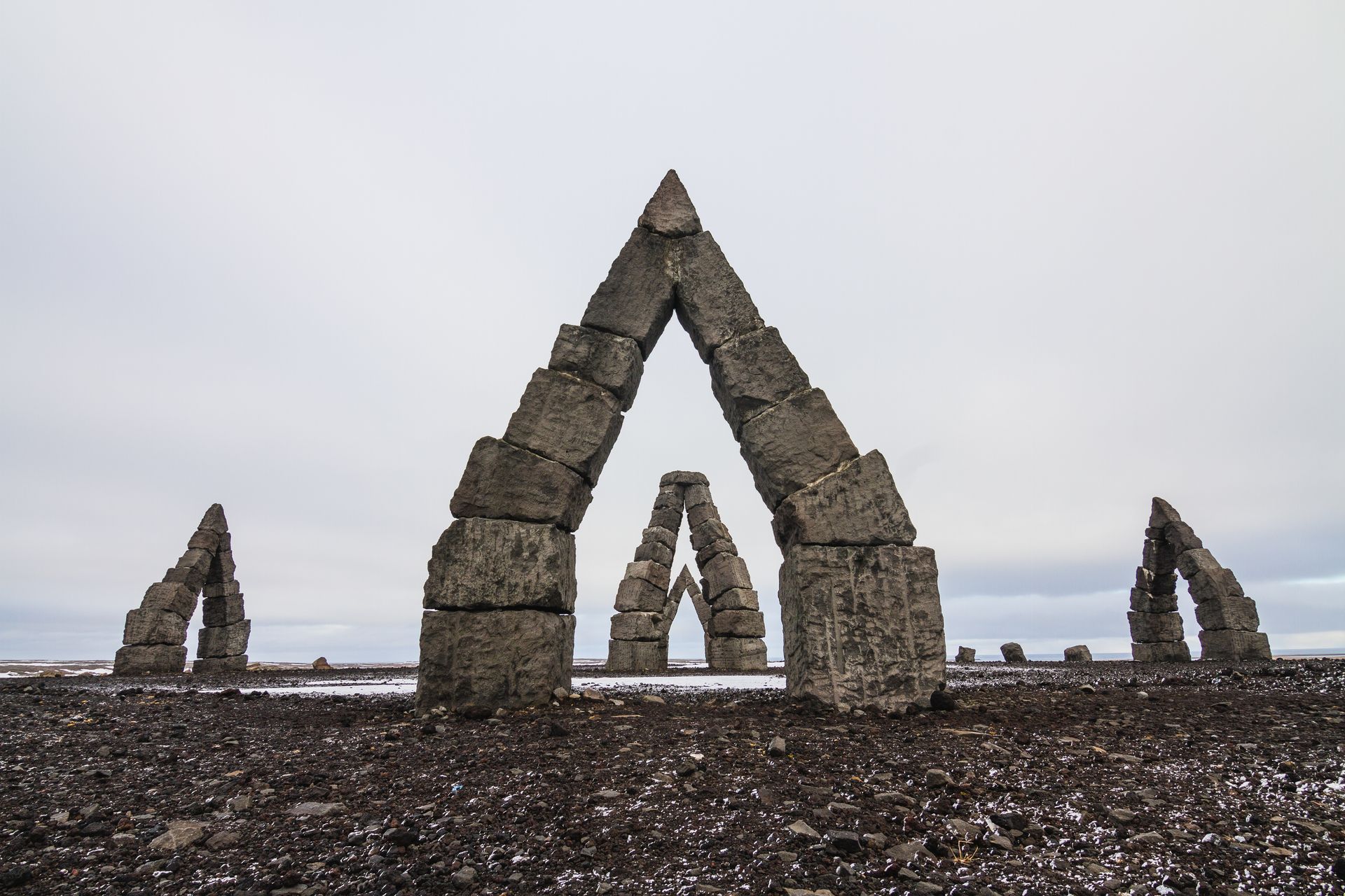 Arctic Henge entouré d'un champ couvert de neige sous un ciel nuageux en Islande Arctic Henge entouré d'un champ couvert de neige sous un ciel nuageux en Islande