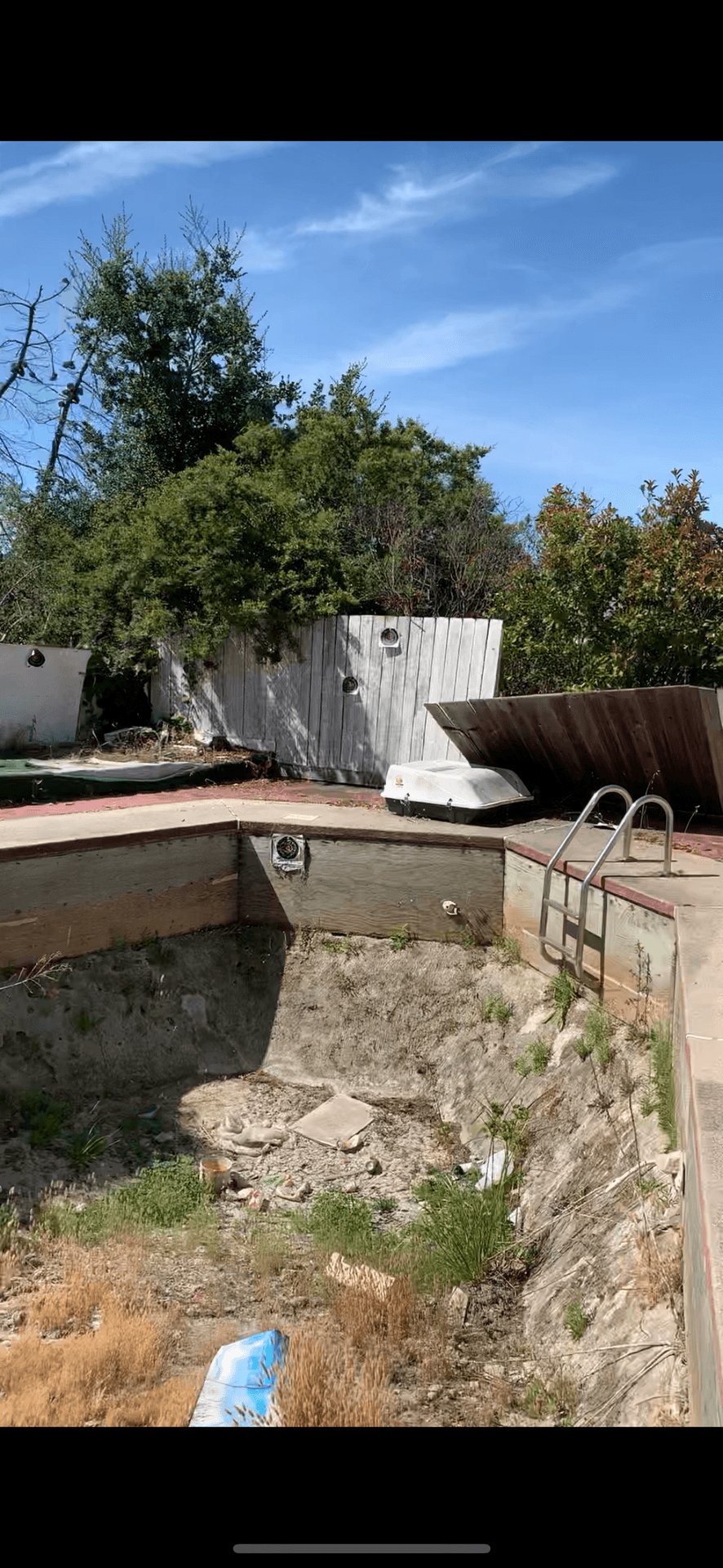 House with damaged pool with broken fence in backyard