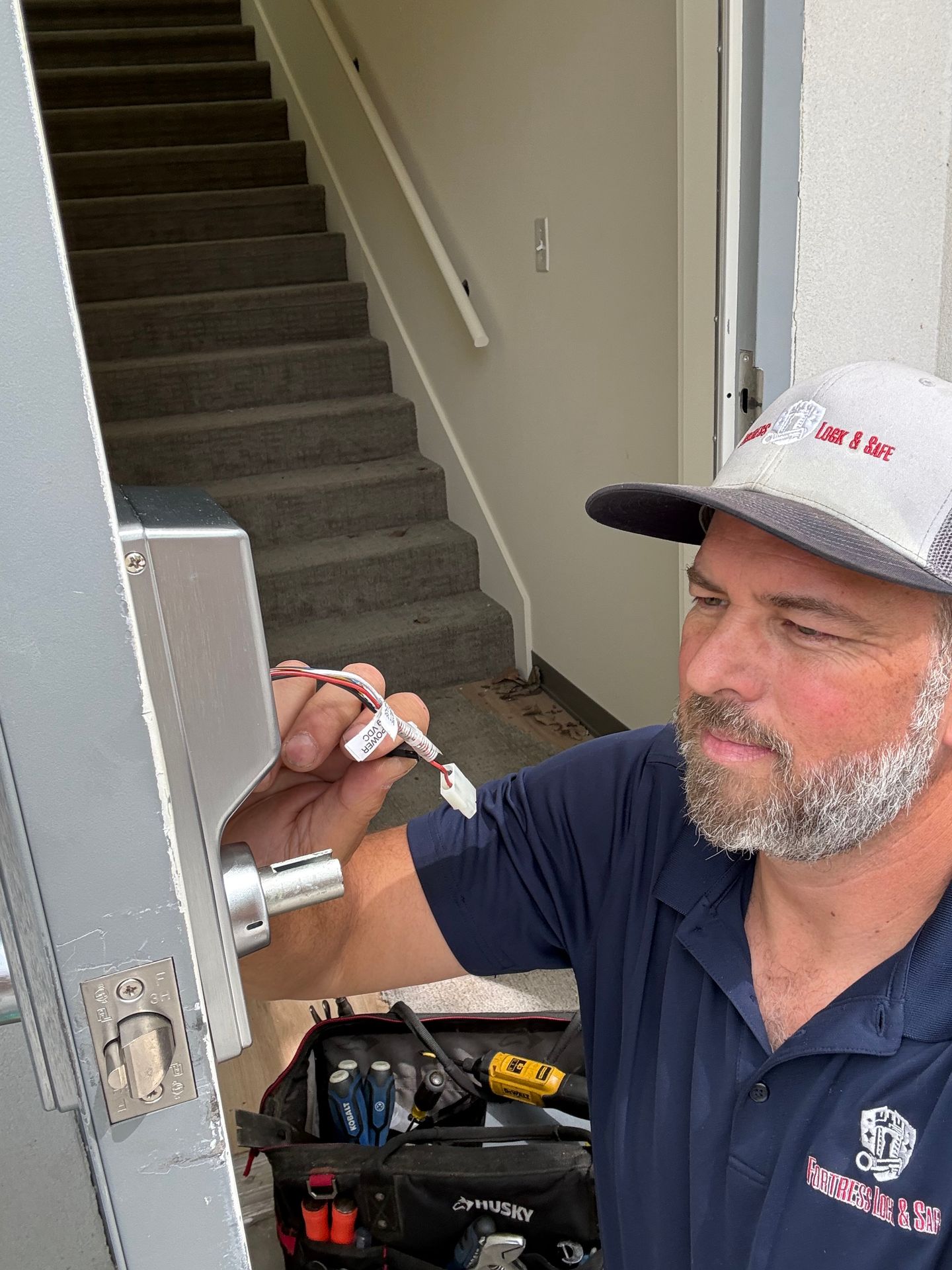 Locksmith's hands using precision tools to repair the internal mechanisms of a residential door lock Locksmith's hands using precision tools to repair the internal mechanisms of a residential door lock