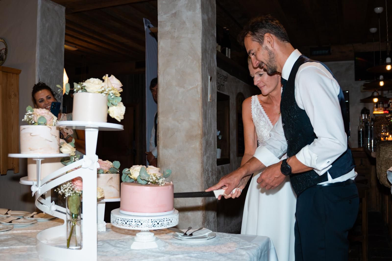Brautpaar schneidet Hochzeitstorte bei ihrer Feier auf der Eidenberger Alm Brautpaar schneidet Hochzeitstorte bei ihrer Feier auf der Eidenberger Alm