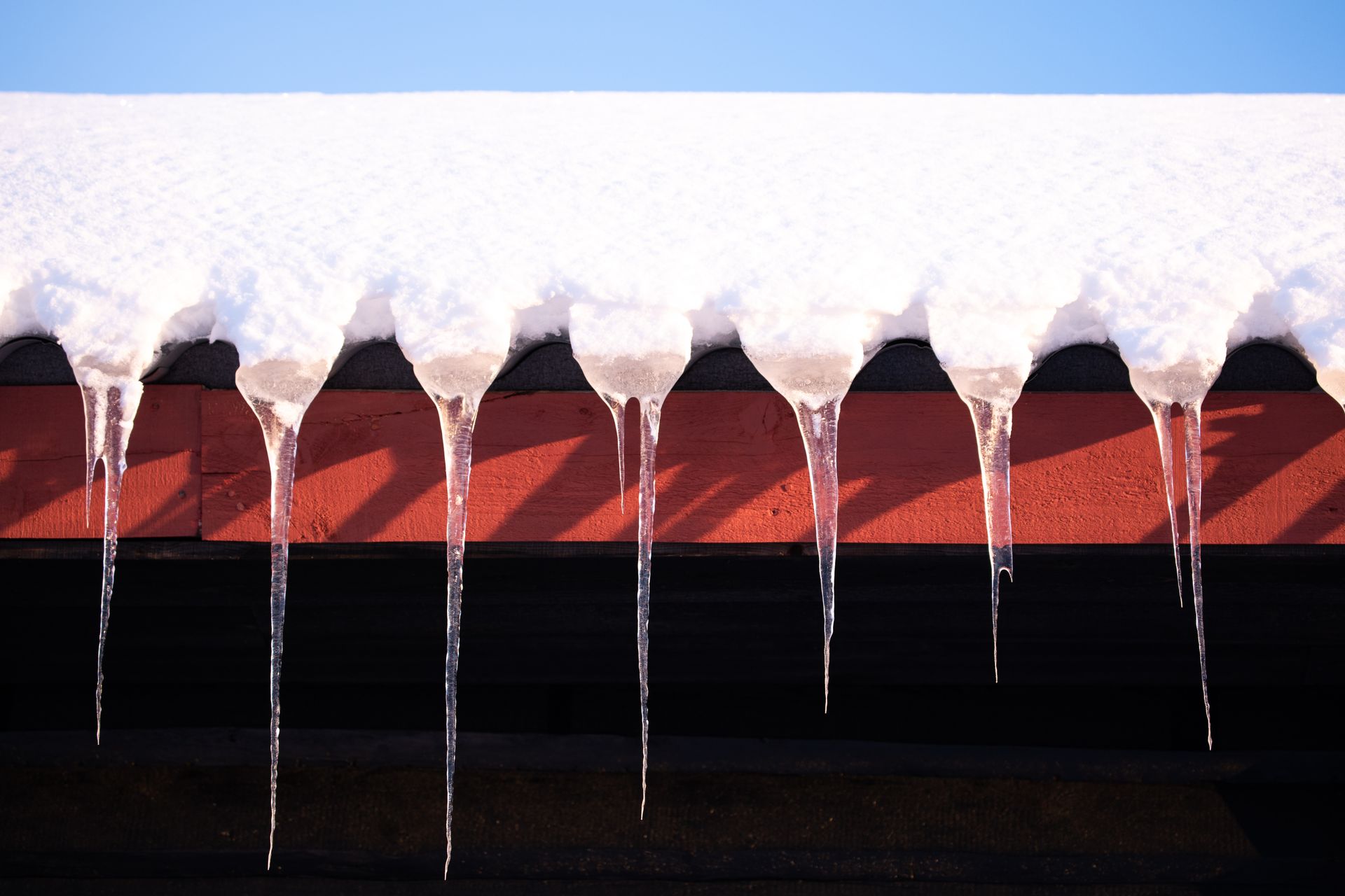 Ice clogged roof gutter with icicles Roofing Contractor West Virginia