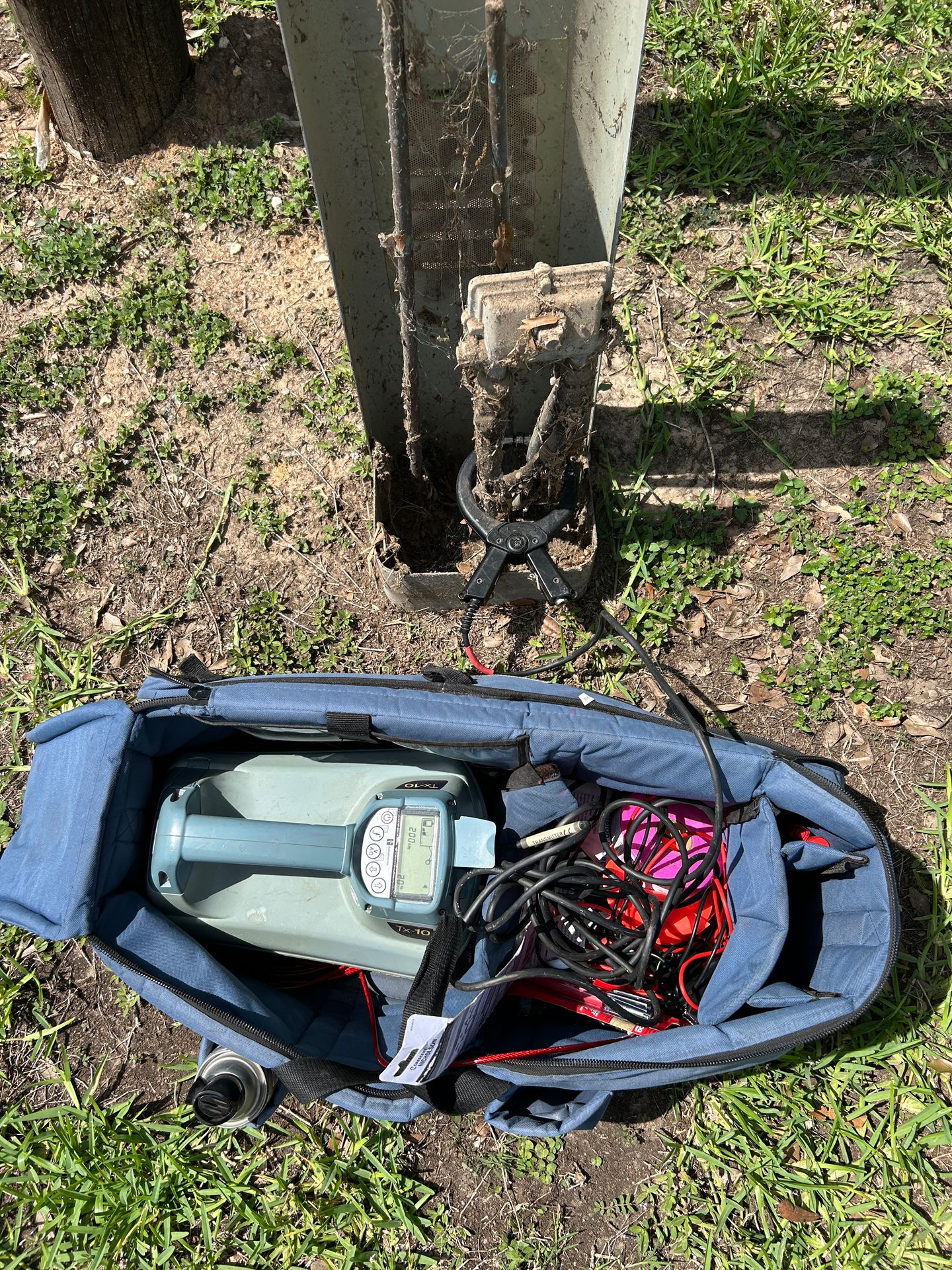 Utility locating technician using equipment near marked underground utilities on a Texas job site
