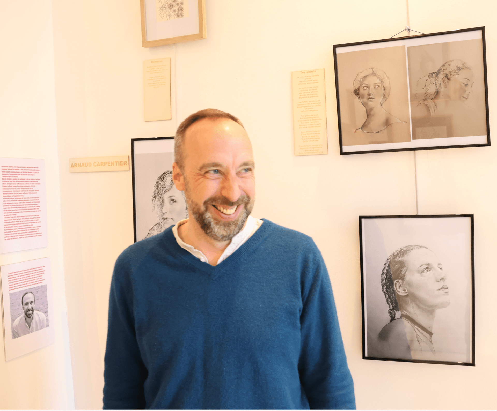 Portrait de l'illustrateur Arnaud Carpentier en pull bleu, devant l'exposition de dessins. Portrait de l'illustrateur Arnaud Carpentier en pull bleu, devant l'exposition de dessins.