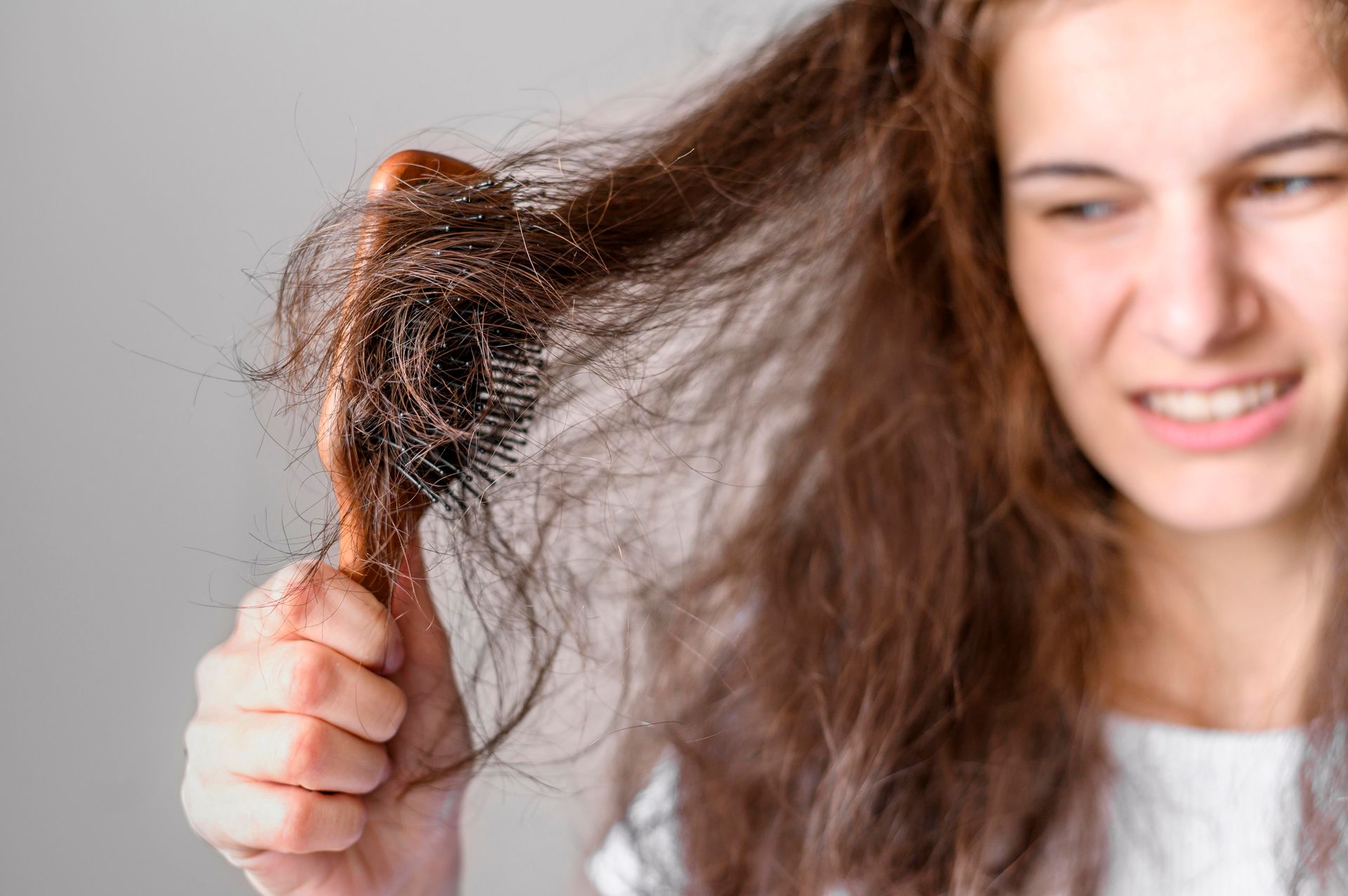 Jeune femme ce brossant les cheveux avec une brosse