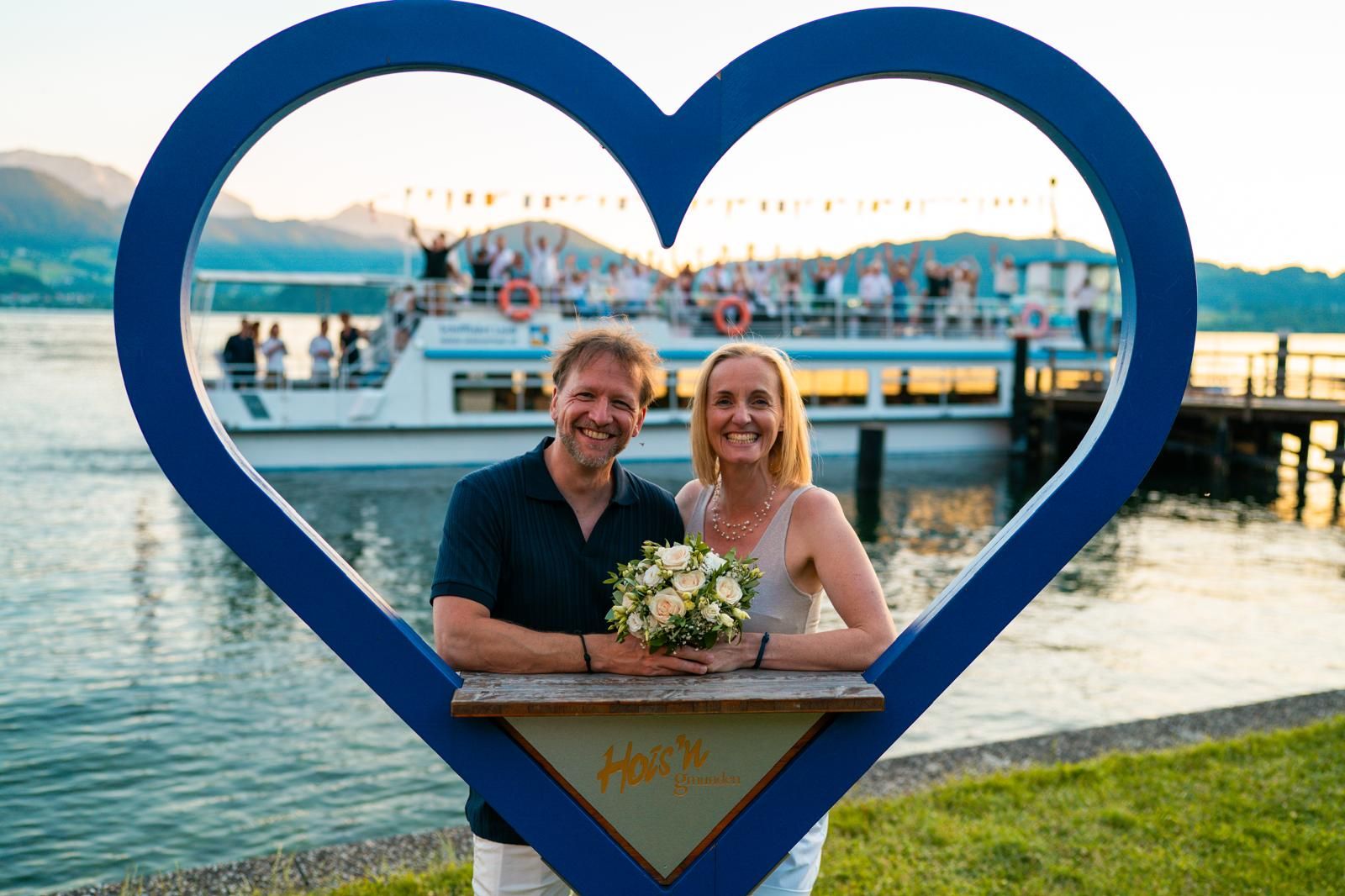 hochzeitsfoto brautpaar mit bilderrahmen am traunsee in ebensee