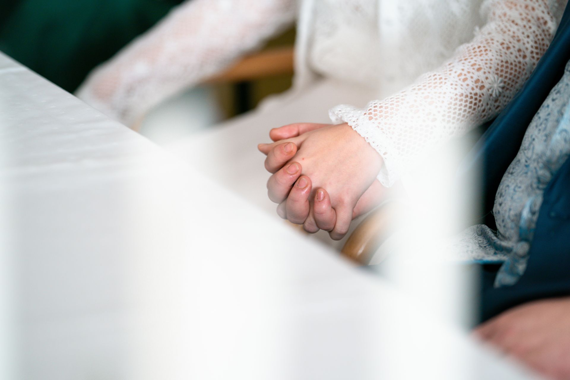 Detailaufnahme von Braut und BrÀutigam, die sich wÀhrend der Trauung liebevoll an den HÀnden halten Detailaufnahme von Braut und BrÀutigam, die sich wÀhrend der Trauung liebevoll an den HÀnden halten