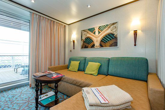 Modern Havana Cabana Suite with a cozy sofa, wall art, soft lighting, and a private balcony overlooking the ocean on a cruise ship. Modern Havana Cabana Suite with a cozy sofa, wall art, soft lighting, and a private balcony overlooking the ocean on a cruise ship.