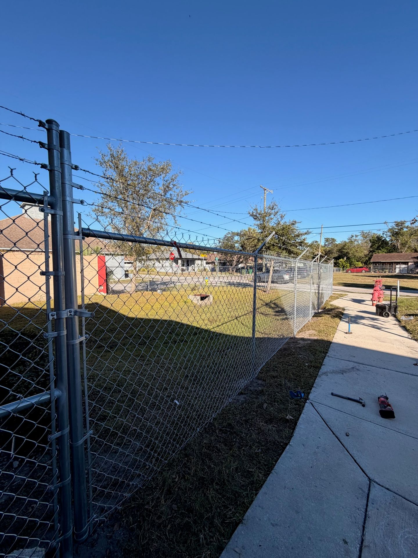 Commercial chain link fence with added security features installed on a business property