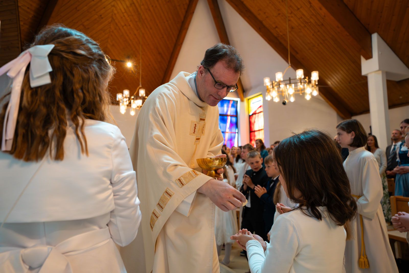 Kind empfängt die heilige Kommunion in der Pfarrkirche Pichling