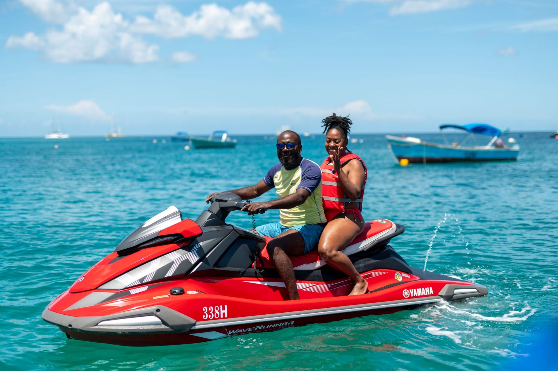 Man drives yellow jet ski on turquoise ocean on a blue day