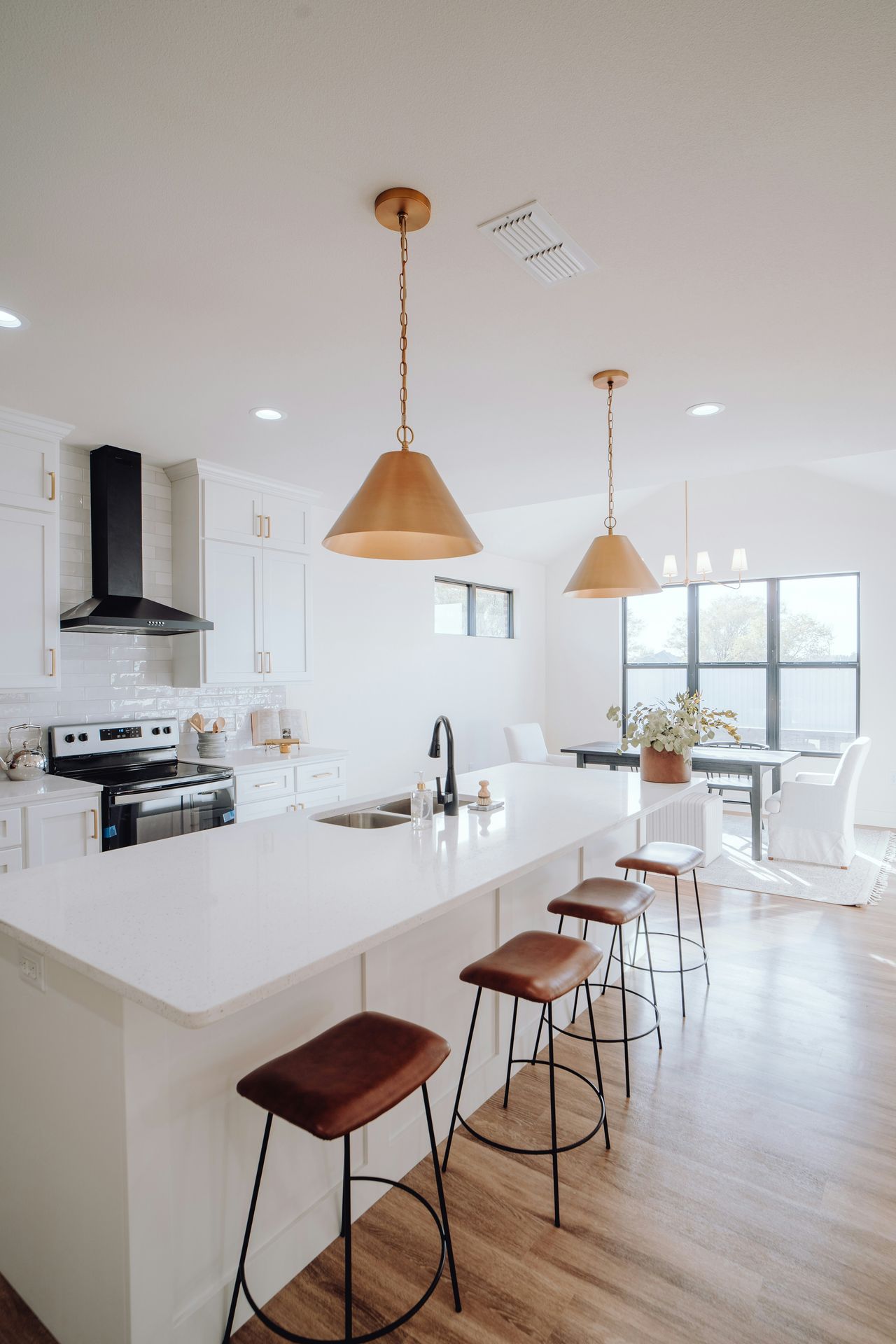 Modern, clutter-free kitchen with minimalist decor, warm pendant lighting, and organized counters — inspiration for home decluttering and organization services in Pearland, Texas.