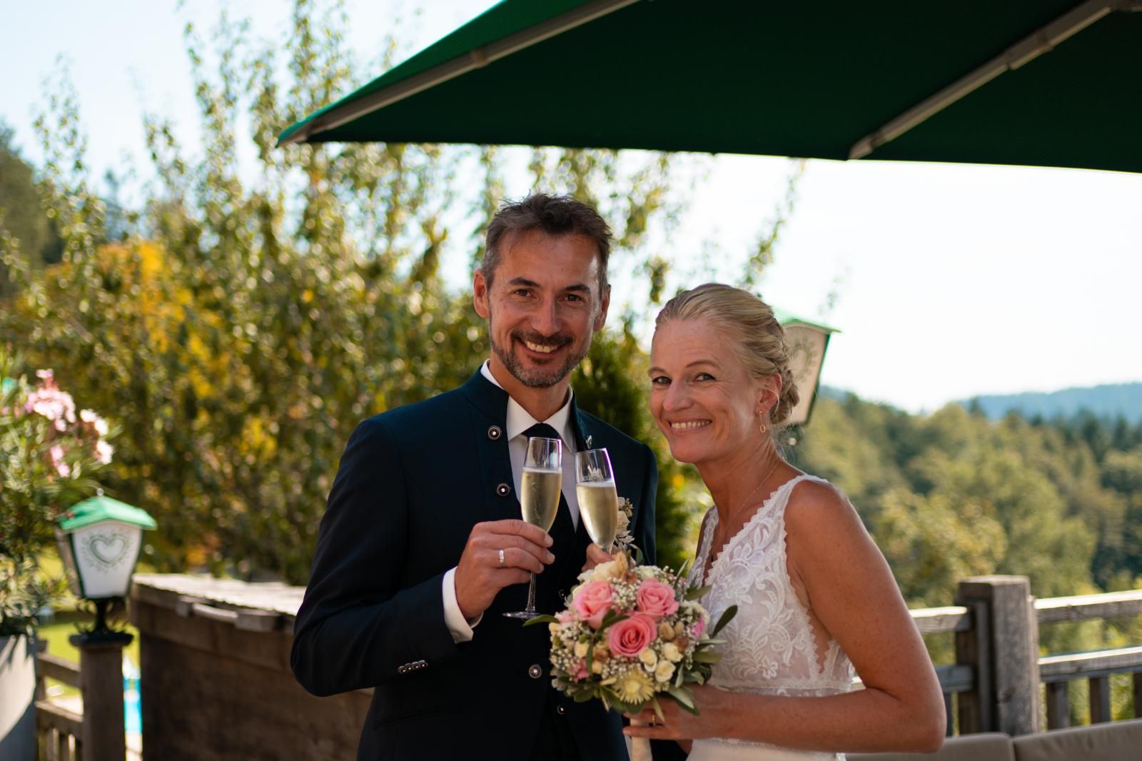 Brautpaar stößt mit Sekt nach der Trauung auf der Eidenberger Alm an Brautpaar stößt mit Sekt nach der Trauung auf der Eidenberger Alm an