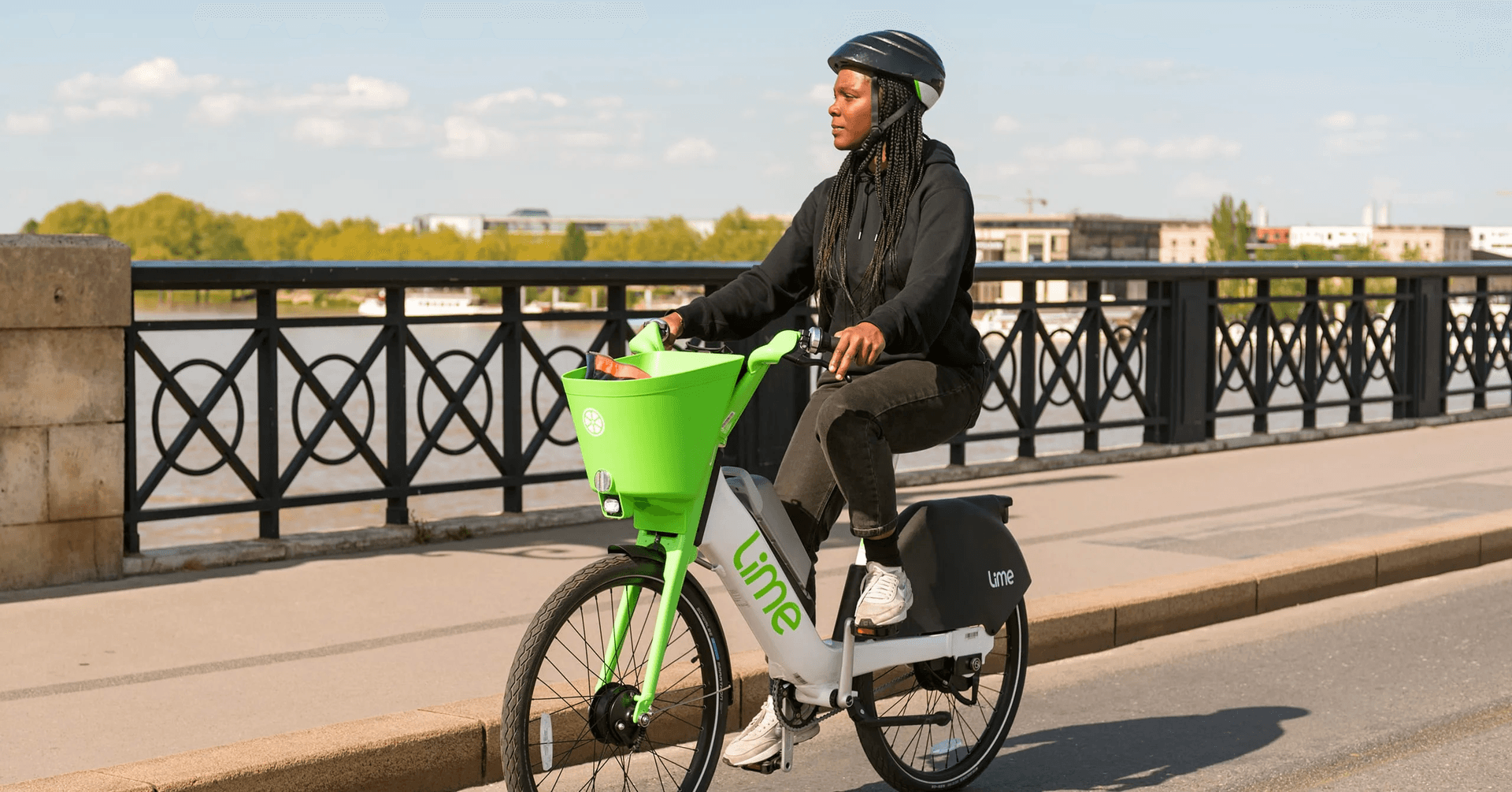 Femme sur un vélo LIME ce baladant sur un pont