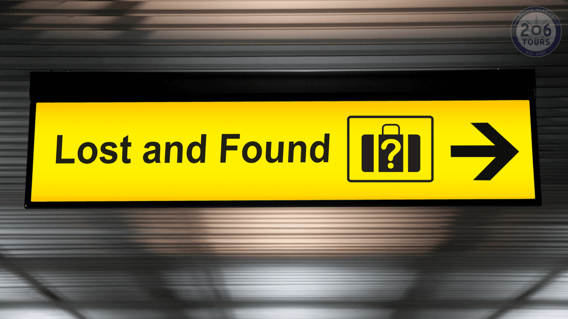 Yellow airport “Lost and Found” sign with a suitcase icon and right-pointing arrow.