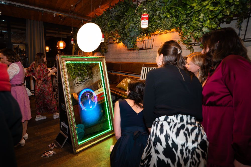 Gäste nutzen Fotobox Magic Mirror bei Hochzeit und lachen vor dem Spiegel