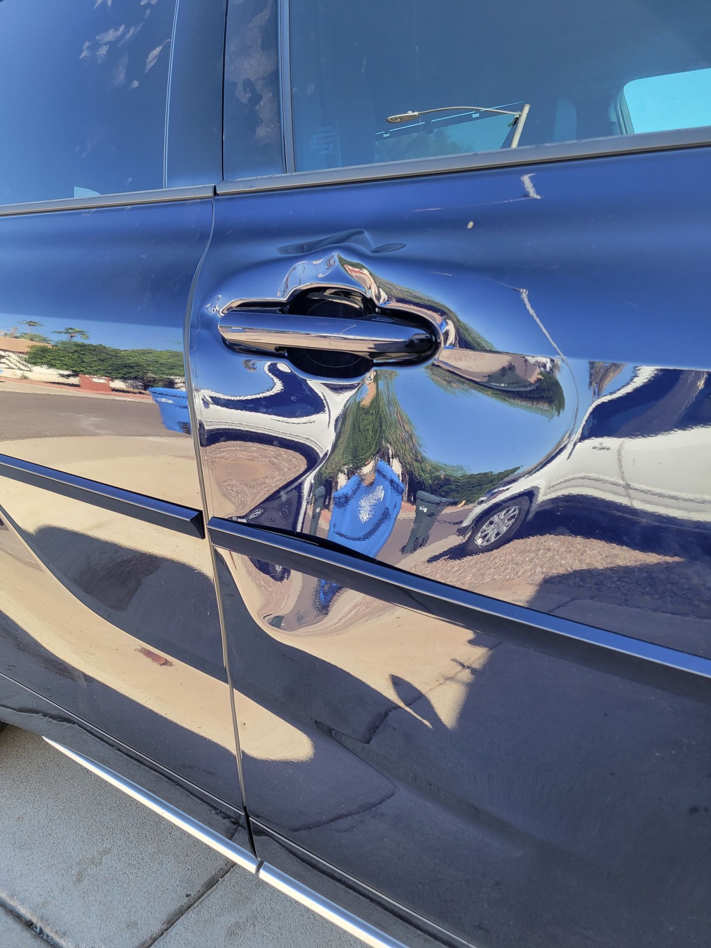 Severe collision-style dent across a Toyota Highlander door