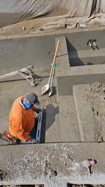 Crew member shaping concrete spa benches and shell details