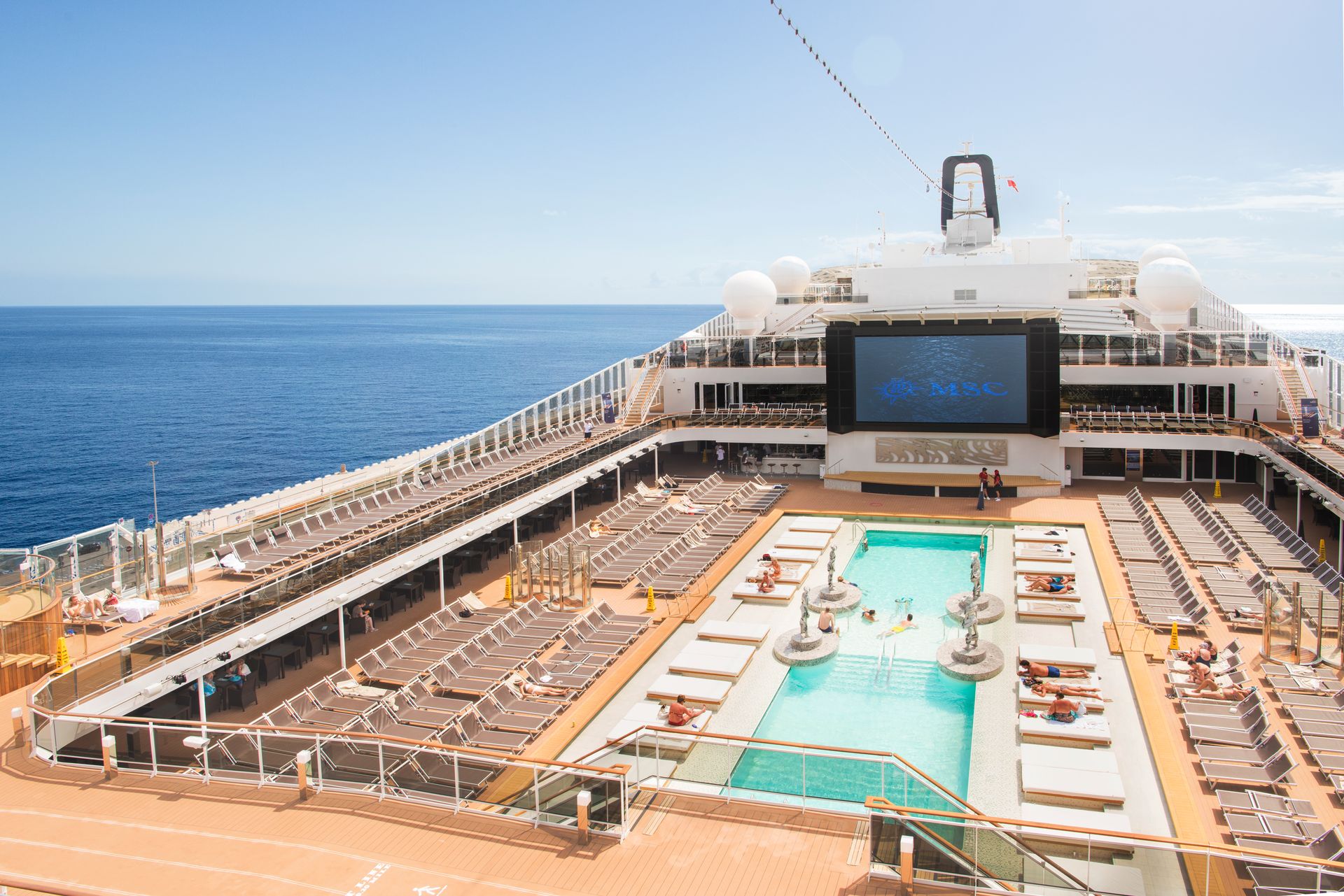 Cruise ship pool deck with loungers overlooking the ocean